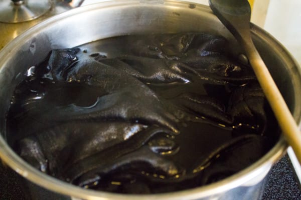 A black liquid dye simmering on a stove.