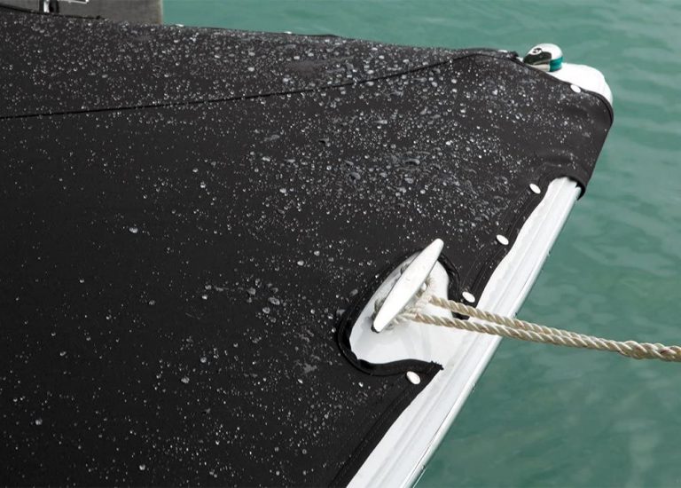 A black tarp on a boat with water on it.