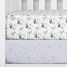 A crib with a grey and blue crib sheet.