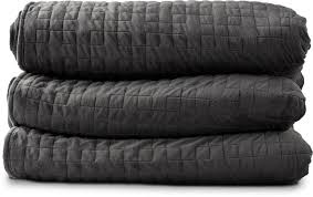 Three black quilted blankets stacked on top of each other.