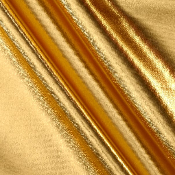 Close-up of a textured gold fabric with diagonal pleats casting soft shadows.